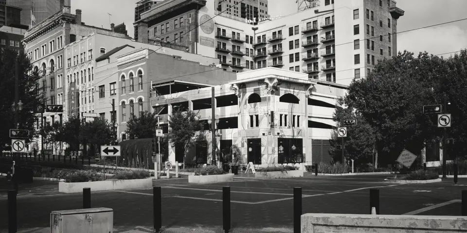 A street corner in downtown Houston with older buildings and towers behind